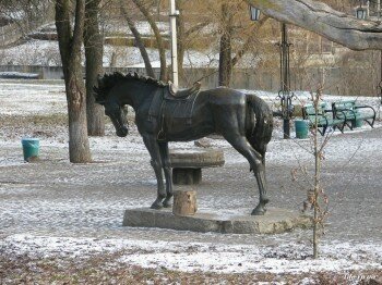 Памятник лошади возле дуба.