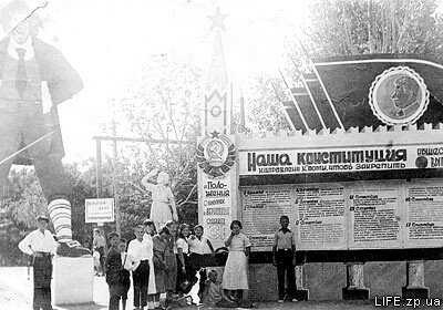 1938 год. Члены фотокружка у входа в Парк металлургов. Стенд с агитацией напоминает нам, что День Конституции в СССР до 1977 года отмечался 5 декабря.