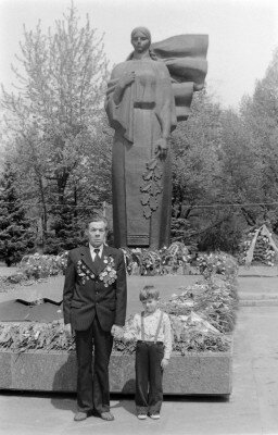 Ветеран с ребенком у мемориала