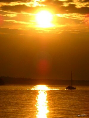Фото сделано в августе 2011 года с речного порта Дубовой рощи. Яхта тонит в золоте заката. Открывается замечательный вид на засыпающую Хортицу.