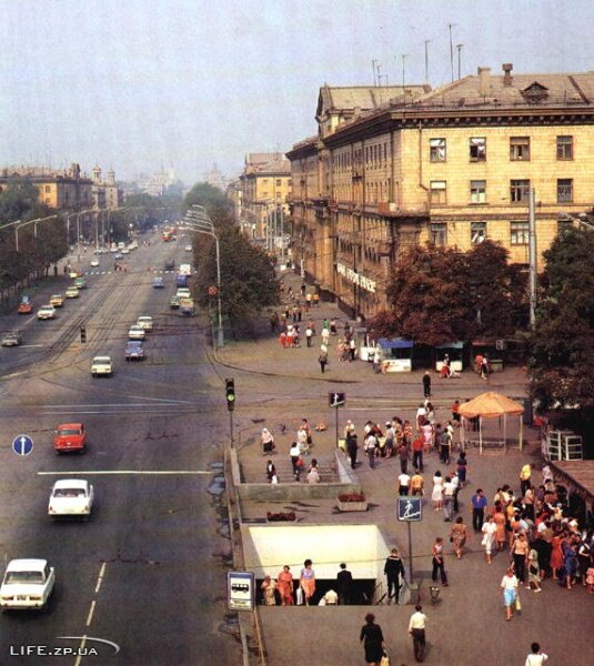 На фото видно как по пр.Ленина еще ездят трамваи. В настоящее время трамвайная линия с проспекта полностью демонтирована.