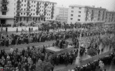 Ноябрь 1962 года. Колонны демонстрантов подходят к пл.Октябрьской. В просвете между жилыми домами ВШ №74.